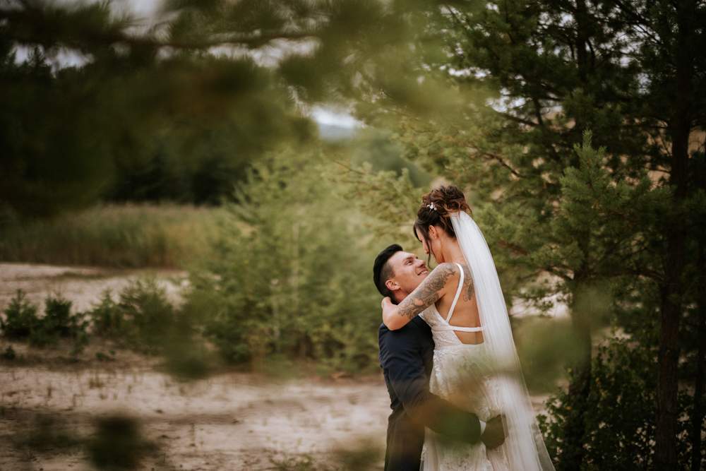 Hochzeitsfotograf-Saalfeld-Sandberge-Remschuetz-durch-baeume Heimlich fotografiert Brautpaar beim turteln