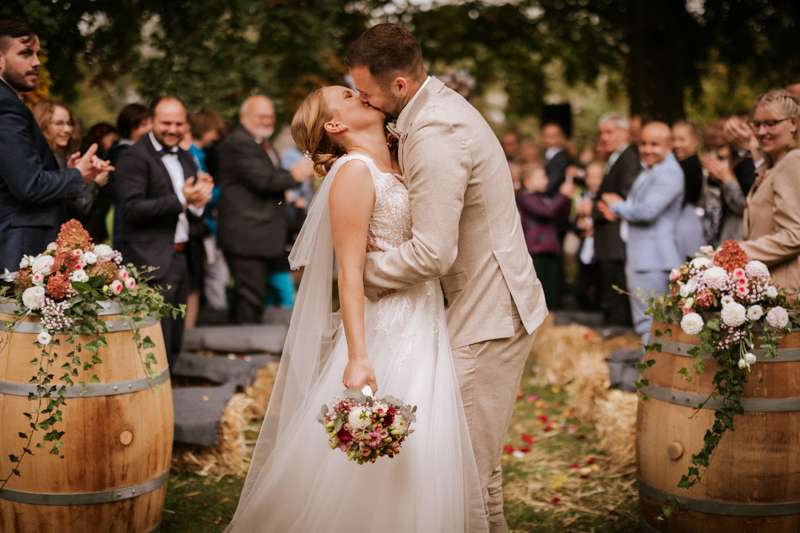 Hochzeitsfotograf-Rudolstadt (29)-Standesamt Route und Bräutigam küssen sich innig während im Hintergrund die Hochzeitsgäste applaudieren